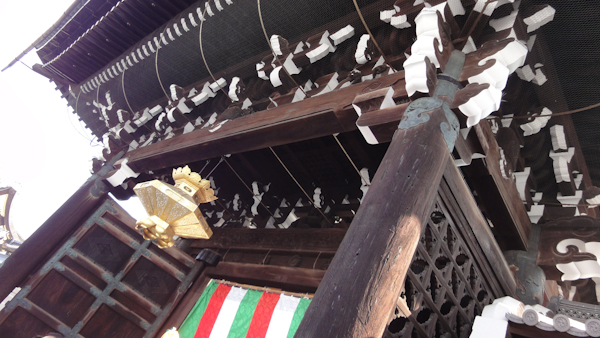a view looking up at the wooden entry gate